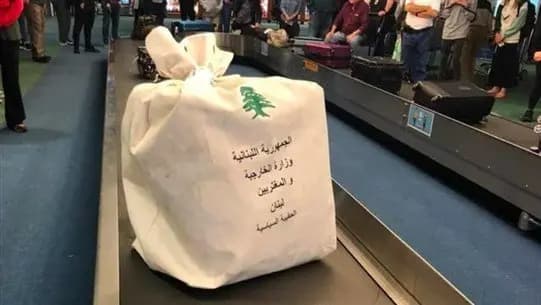 بالصورةِ :صندوقُ اقتراعٍ مليءٍ بأصواتِ الناخبين، يدور على حزام حقائب السفر في مطار بورتلاند- الولايات المتحدة الأميركية